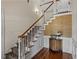 Elegant staircase featuring hardwood floors, white banisters, and a decorative accent table at 184 Melissa Trl, Auburndale, FL 33823