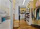 Walk-in closet with adjacent laundry room featuring custom shelving and plentiful storage at 184 Melissa Trl, Auburndale, FL 33823