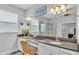 Bright bathroom featuring double sinks, a vanity area, a large mirror, and a walk-in shower with a glass door at 1902 Altavista Cir, Lakeland, FL 33810