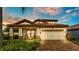 Inviting single-story home with well-manicured landscaping, a brick driveway, and a two-car garage at 1902 Altavista Cir, Lakeland, FL 33810