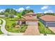 Charming single-Gathering home featuring a tile roof, a paver driveway, and a lush, landscaped front yard at 1902 Altavista Cir, Lakeland, FL 33810