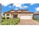 Charming home with a tiled roof, brick driveway, and inviting front porch with seating at 1902 Altavista Cir, Lakeland, FL 33810