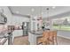 Well-lit kitchen featuring white cabinets, stainless steel appliances, a large island, and a view of the neighborhood at 1902 Altavista Cir, Lakeland, FL 33810