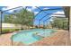 A view of the in-ground pool with an in-ground spa inside the full screened-in enclosure at 1902 Altavista Cir, Lakeland, FL 33810