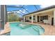 Inviting pool with in-ground spa and brick deck beneath screened enclosure at 1902 Altavista Cir, Lakeland, FL 33810