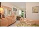 Relaxing bedroom with dresser, mirror, palm tree lamp, chair, and view into the next room at 1970 Michael Tiago Cir, Maitland, FL 32751