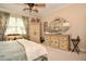 Comfortable bedroom features an antique dresser with mirror, armoire, a chair, and carpeted floor at 1970 Michael Tiago Cir, Maitland, FL 32751