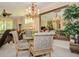 Formal dining room with elegant chairs, a glass-topped table, chandelier and a decorative mirror creating an open feel at 1970 Michael Tiago Cir, Maitland, FL 32751