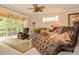 Inviting living room with a plush chaise lounge, sliding glass doors to a patio, and a decorative ceiling fan at 1970 Michael Tiago Cir, Maitland, FL 32751