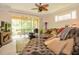 Inviting living room with a plush chaise lounge, sliding glass doors to a patio, and a decorative ceiling fan at 1970 Michael Tiago Cir, Maitland, FL 32751