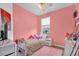 Cozy bedroom with a pink accent wall, soft rug, and comfortable furnishings at 2061 Crestdale Ln # 60, Lake Mary, FL 32746