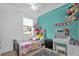 Bright bedroom featuring a teal accent wall, plush carpet, and lots of stuffed animals at 2061 Crestdale Ln # 60, Lake Mary, FL 32746