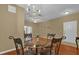 Inviting dining area featuring a chandelier, hardwood floors, and a glass-top table with seating for four at 2061 Crestdale Ln # 60, Lake Mary, FL 32746
