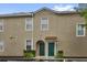 Beige townhouse featuring two front doors, each adorned with planters and greenery at 2061 Crestdale Ln # 60, Lake Mary, FL 32746