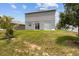 Spacious backyard featuring a lush lawn, trees, a white vinyl fence and sliding glass doors providing access to the home at 2850 Sanderling St, Haines City, FL 33844