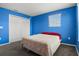 Bright bedroom featuring blue walls, carpeted floors, closet, and a window at 2850 Sanderling St, Haines City, FL 33844