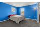 Bright bedroom with blue walls, carpeted floors, and two windows providing ample natural light at 2850 Sanderling St, Haines City, FL 33844