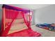 bedroom with canopy bed, pink rug, and race car bed at 2850 Sanderling St, Haines City, FL 33844