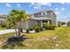 Charming two-story home with a manicured lawn and vibrant landscaping featuring a palm tree at 2850 Sanderling St, Haines City, FL 33844