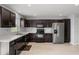 Modern kitchen with dark cabinets, stainless steel appliances, and bright white countertops at 2850 Sanderling St, Haines City, FL 33844