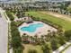 Aerial view of community pool surrounded by palm trees, grassy areas, and a playground at 2850 Sanderling St, Haines City, FL 33844