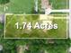 Aerial view of the 1.74 acre lot with yellow-highlighted property lines, lush trees, and a private pool at 2921 W Socrum Loop Rd, Lakeland, FL 33810