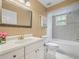 Well-lit bathroom featuring white vanity, a framed mirror and tiled shower at 2921 W Socrum Loop Rd, Lakeland, FL 33810