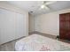 Bedroom with white closet doors, ceiling fan and wood-look flooring at 2921 W Socrum Loop Rd, Lakeland, FL 33810