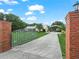 Long driveway leading to a well-maintained home with a horse-themed gate and covered parking at 2921 W Socrum Loop Rd, Lakeland, FL 33810