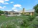 Exterior rear view of the house with a metal roof, screened-in pool, and wooded surroundings at 2921 W Socrum Loop Rd, Lakeland, FL 33810
