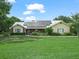 Charming single-story home with solar panels, manicured lawn, brick accents, and lush landscaping at 2921 W Socrum Loop Rd, Lakeland, FL 33810
