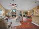 Cozy living room features a brick fireplace, hardwood floors, and comfortable seating arrangement at 2921 W Socrum Loop Rd, Lakeland, FL 33810