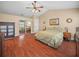 Main bedroom with wood floors, ceiling fan, and mirrored closet doors at 2921 W Socrum Loop Rd, Lakeland, FL 33810