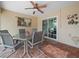 A covered patio features brick floors, a ceiling fan, and sliding glass doors leading to outdoor space at 2921 W Socrum Loop Rd, Lakeland, FL 33810