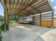 RV parking with a covered metal structure, gravel, and hookups in a wooded setting with blue skies at 2921 W Socrum Loop Rd, Lakeland, FL 33810