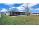 The backyard boasts a screened patio with views of the manicured lawn at 2966 Flying Blackbird Rd, Bartow, FL 33830