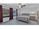 Cozy bedroom with a gray patterned bedspread, neutral walls, and ample natural light at 2966 Flying Blackbird Rd, Bartow, FL 33830