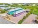 This aerial view shows the home, lush lawn, mature landscaping, and a tiki hut at 3052 Wood Duck Dr, Polk City, FL 33868