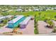 This aerial view shows the home, paver driveway, mature landscaping, and a tiki hut at 3052 Wood Duck Dr, Polk City, FL 33868