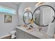 Bright bathroom with double vanity, modern fixtures, and a large round mirror at 3052 Wood Duck Dr, Polk City, FL 33868