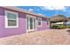 A charming purple home featuring a tiki hut-covered patio and white trim, creating a serene outdoor living space at 3052 Wood Duck Dr, Polk City, FL 33868