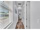 Bright hallway with hardwood floors, white trim, and view to the outdoors through window blinds at 3052 Wood Duck Dr, Polk City, FL 33868