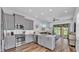 Well-equipped kitchen with stainless steel appliances, gray cabinetry, and view to comfortable living area at 3052 Wood Duck Dr, Polk City, FL 33868