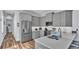 Modern kitchen with gray cabinets, stainless steel appliances, and hardwood floors, perfect for cooking and entertaining at 3052 Wood Duck Dr, Polk City, FL 33868
