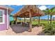 Thatched roof Tiki hut with patio furniture with a ceiling fan above, creating an island-inspired retreat at 3052 Wood Duck Dr, Polk City, FL 33868