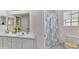 Bathroom with double sinks, white cabinets, and a combination tub and shower at 3107 Stonewater Dr, Lakeland, FL 33803