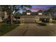 Charming townhome showing a two-car garage, inviting curb appeal, and lush landscaping at sunset at 3107 Stonewater Dr, Lakeland, FL 33803