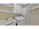 Laundry room with washer, dryer, sink, and storage shelves at 3107 Stonewater Dr, Lakeland, FL 33803
