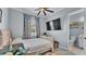 Light-filled bedroom with a ceiling fan, TV and en suite bathroom, decorated in a calming blue at 3270 Green Heron Dr, Polk City, FL 33868