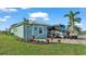 Exterior view of the home featuring an RV, golf cart, palm trees, and landscaping at 3270 Green Heron Dr, Polk City, FL 33868